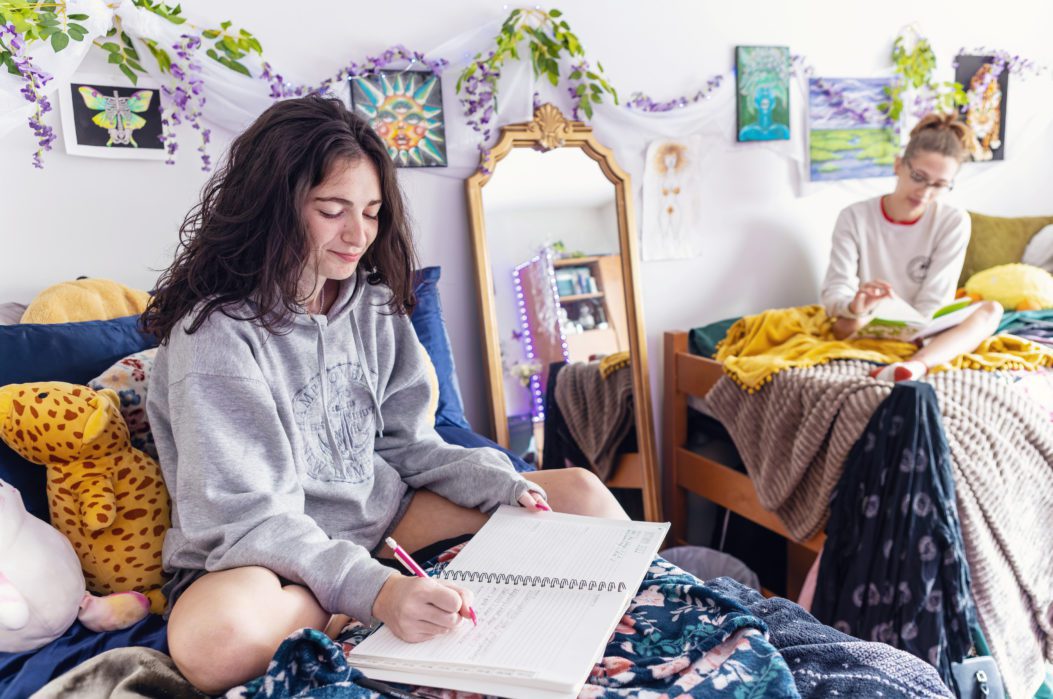 residence hall reeom with purple and green flower decor and student reading