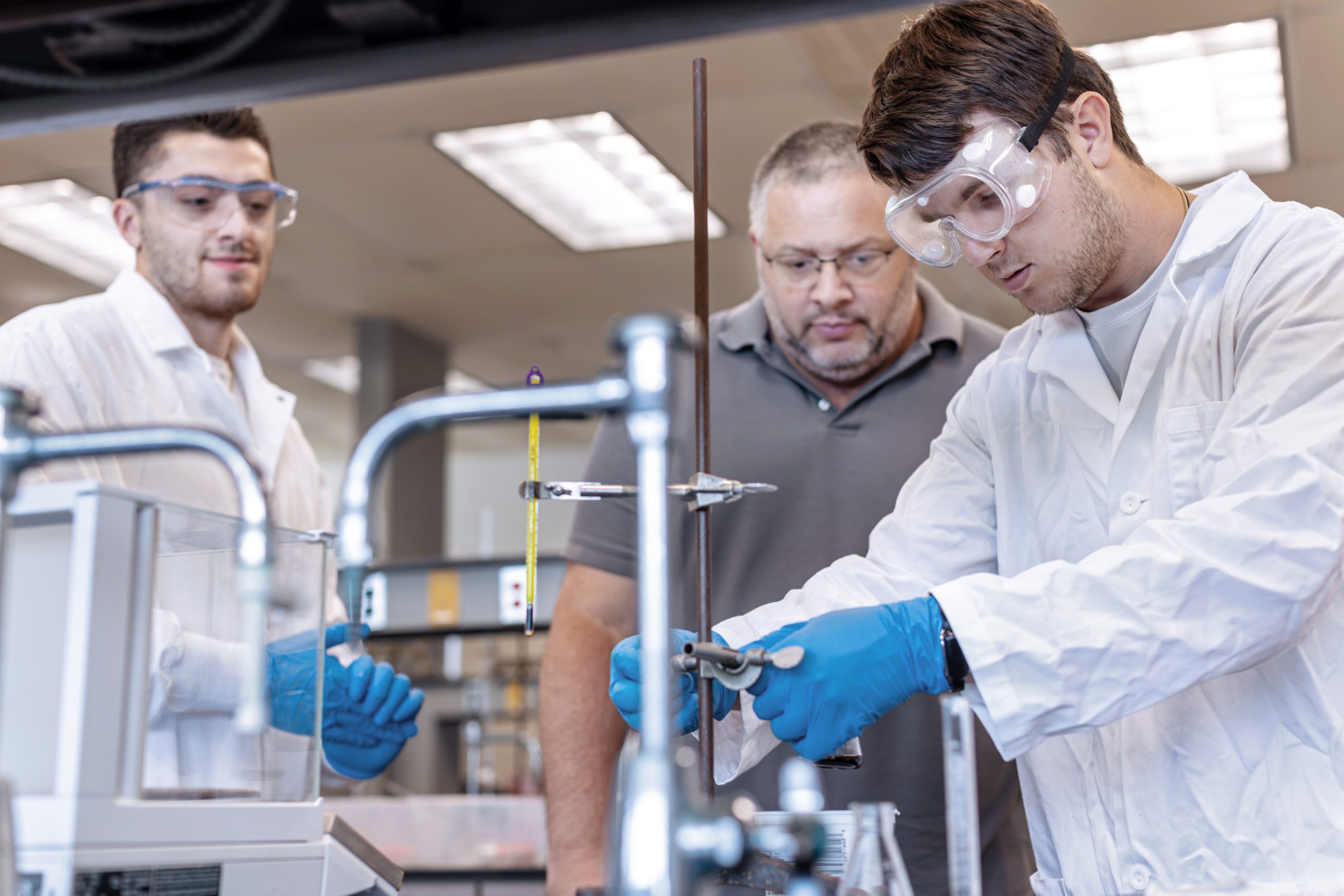 Two students with professor in Biotechnology lab