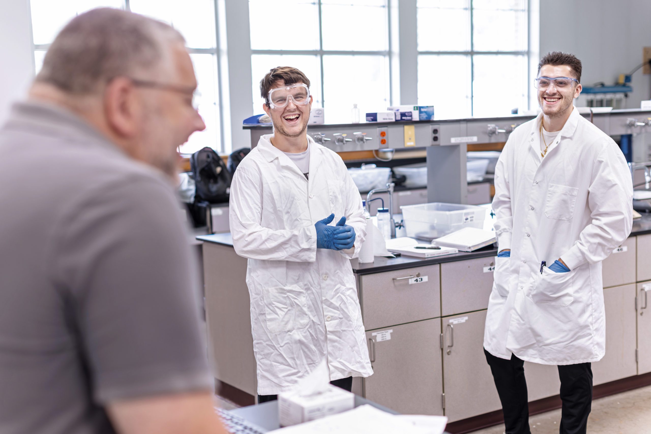 Dr. Burns with two students in a lab.