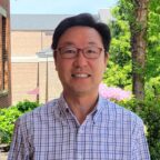 Siyong smiling outside with trees in background