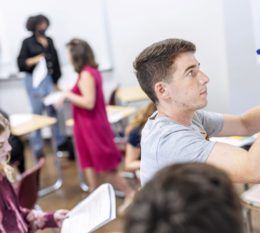 Students in a classroom writing on white boards.