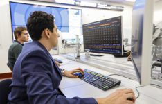 Two male students sitting at desks in the Bloomberg lab working on computers.