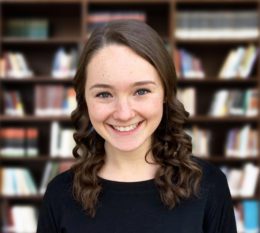 Student in front of Book shelf