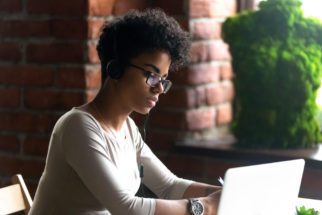 A female student sitting at a desk working on a laptop