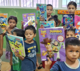 Small kids in school in El Salvador unpacking gift from STAC