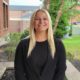 Victoria smiling outside of Borelli Hall wearing black shirt and blazer jacket