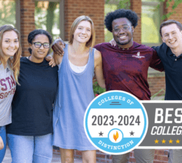 5 students standing arm in arm smiling outside of Borelli Hall