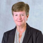 Margaret smiling wearing black and white shirt and black blazer