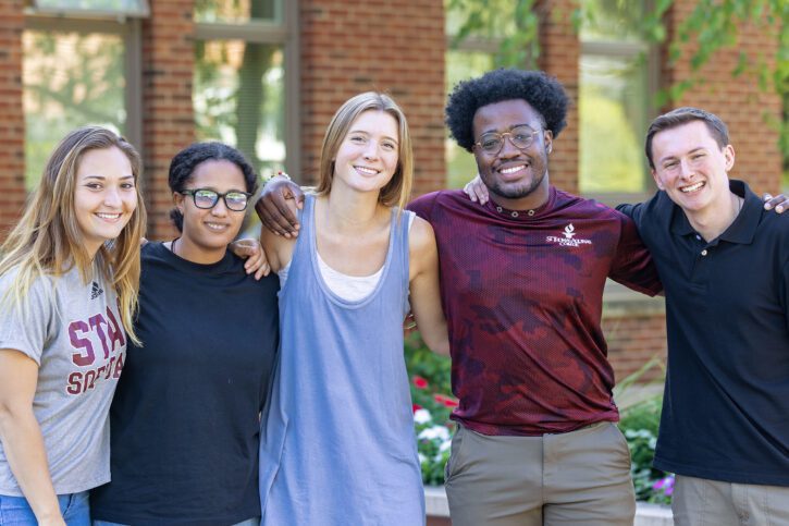 5 students smiling in front of borelli hall