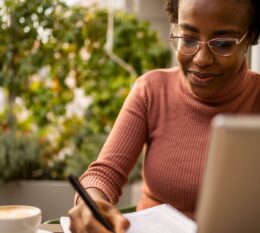 Student studying online and writing notes