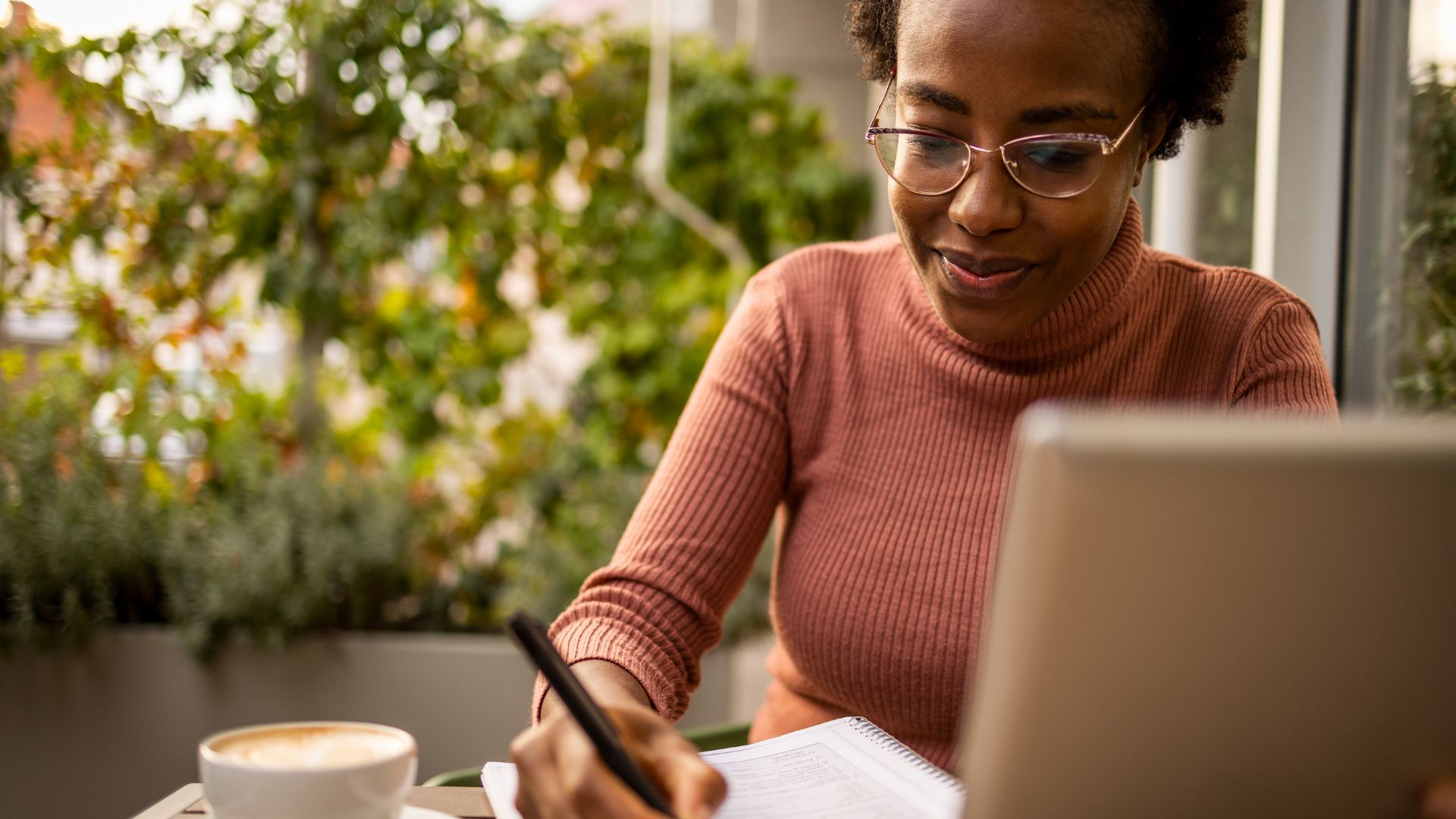 Student studying online and writing notes