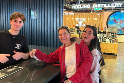 Devin smiling with two family members while at Distillery