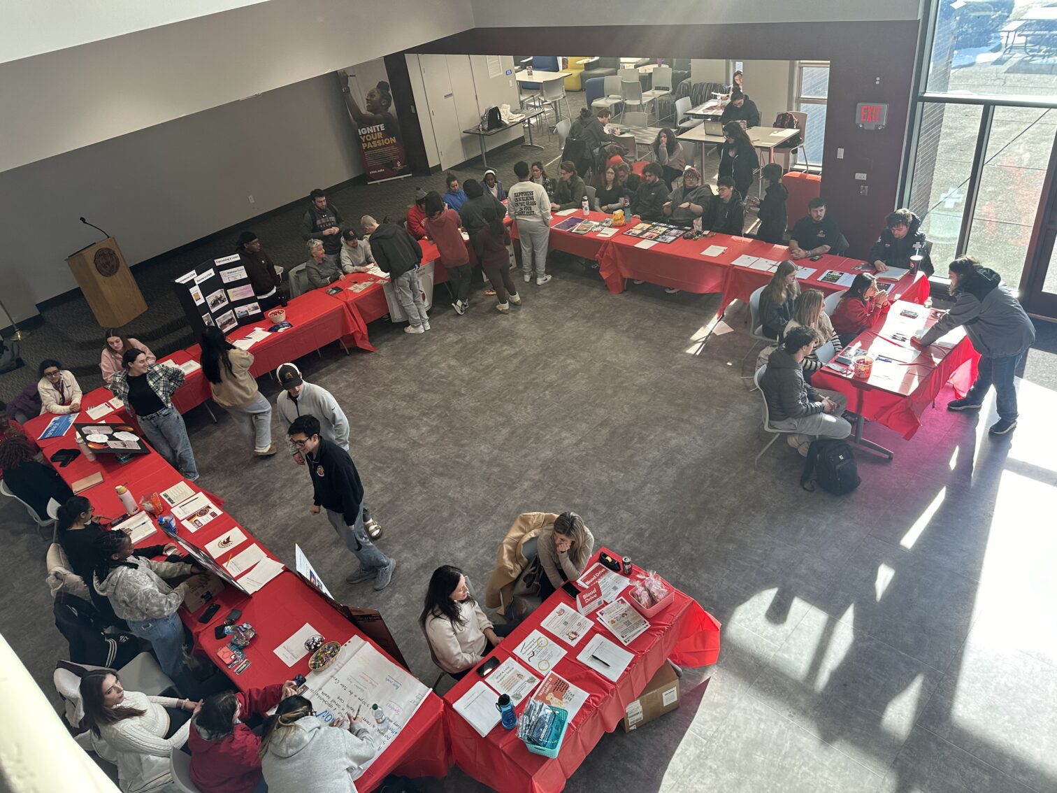 overhead image of students in the Romano Center at club fair tables