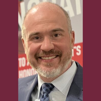 John smiling wearing suit and tie