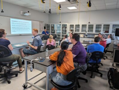 Professors in STEM lab classroom working on group projects during Academy