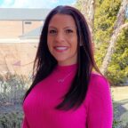 Stacy Toriello smiling wearing pink sweater outside