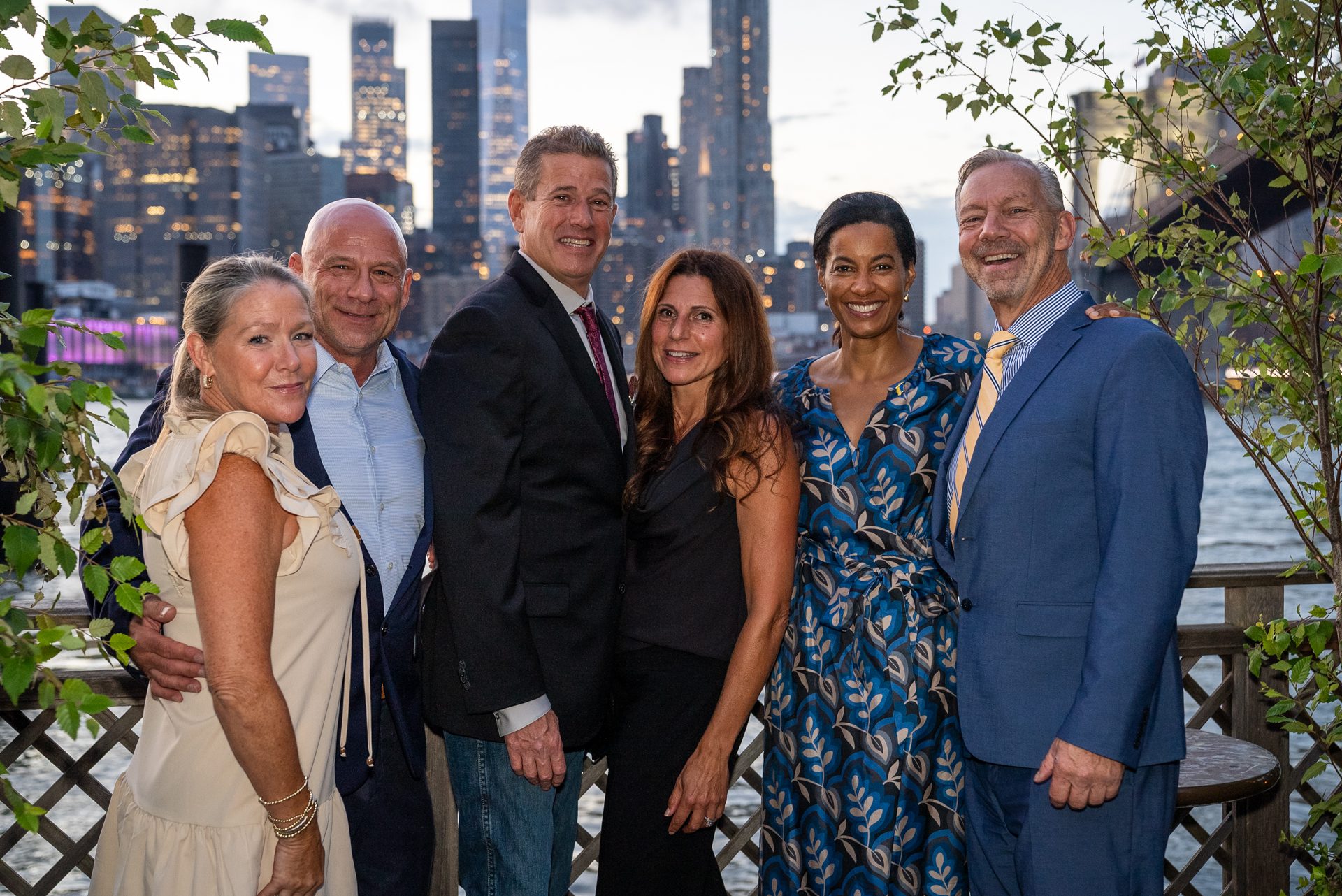 six people wearing professional dress clothing with the skyline in the background