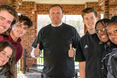 Ken Daly surrounded by students