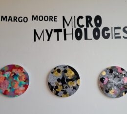 Margo Moore Micro-Mythologies text with three colorful circular designs on wall
