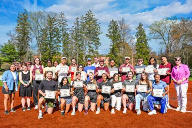 Group of 4.0 student athletes and administration on field smiling for group photo